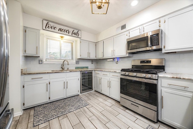 5796 N Foxburrow Cir, Memphis, TN 38115 - kitchen with stainless steel appliances, a sink, beverage cooler, decorative backsplash, and recessed lighting