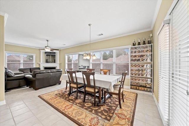 1166 Sanbyrn Dr, Cordova, TN 38018 - dining room featuring light tile patterned floors, a fireplace, healthy amount of natural light, crown molding, and a chandelier