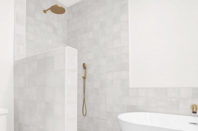 1995 Walker Ave, Memphis, TN 38104 - full bathroom with walk in shower, a freestanding tub, and tile walls