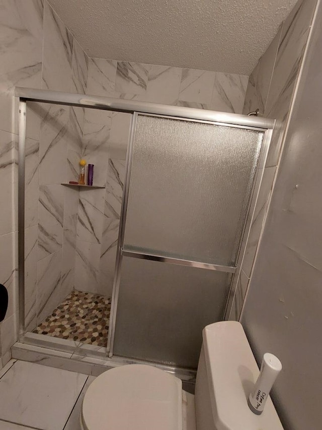 5647 Maple Tree Dr, Memphis, TN 38115 - bathroom with toilet, a shower stall, a textured ceiling, and marble finish floors