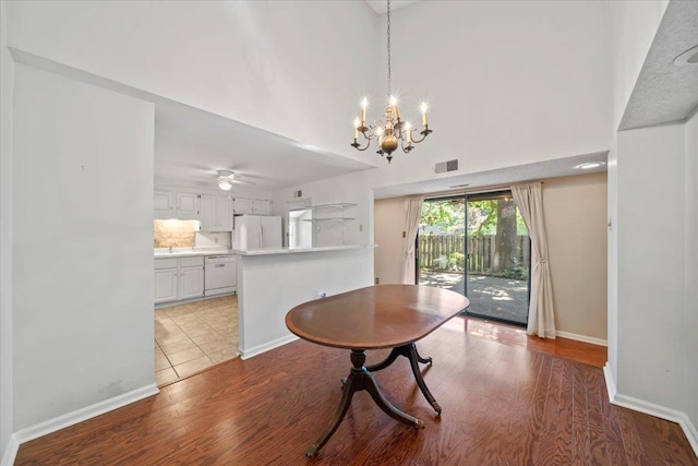 8174 Ravenhill Dr Unit 54, Germantown, TN 38138 - dining room featuring wood finished floors, a chandelier, baseboards, a ceiling fan, and a high ceiling