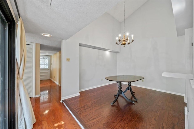 8174 Ravenhill Dr Unit 54, Germantown, TN 38138 - unfurnished dining area featuring wood finished floors, a textured ceiling, a chandelier, baseboards, and high vaulted ceiling