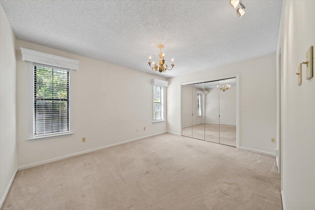 8174 Ravenhill Dr Unit 54, Germantown, TN 38138 - unfurnished bedroom with a chandelier, carpet flooring, a textured ceiling, baseboards, and a closet