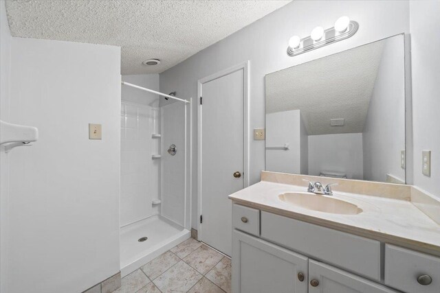 8174 Ravenhill Dr Unit 54, Germantown, TN 38138 - bathroom featuring a textured ceiling, vanity, a shower, and tile patterned floors