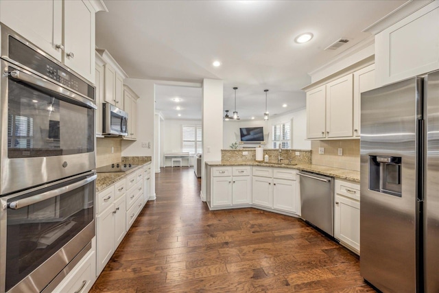 1668 Jennings Mill Ln, Collierville, TN 38017 - kitchen featuring stainless steel appliances, recessed lighting, decorative backsplash, a peninsula, and dark wood-style flooring
