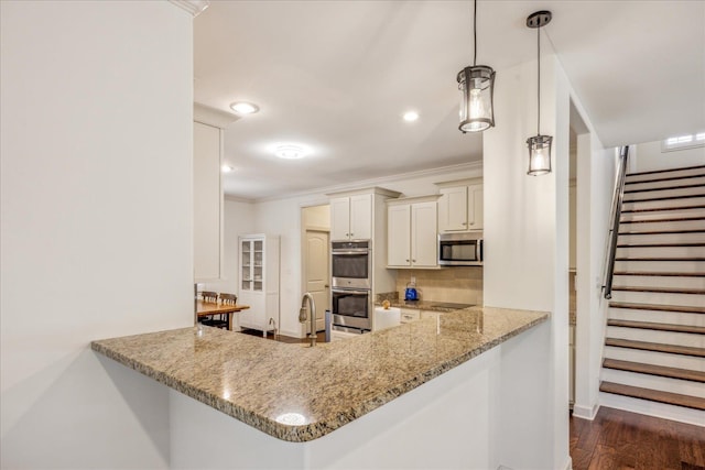 1668 Jennings Mill Ln, Collierville, TN 38017 - kitchen featuring stainless steel appliances, light stone countertops, decorative backsplash, baseboards, and a peninsula