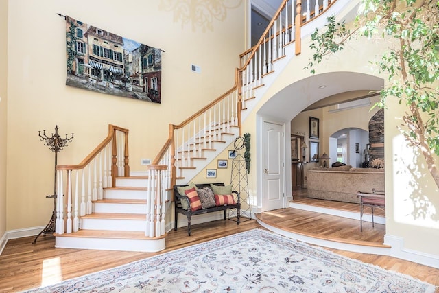 1245 Auburn Woods Dr, Collierville, TN 38017 - foyer featuring a towering ceiling, wood finished floors, arched walkways, stairs, and baseboards