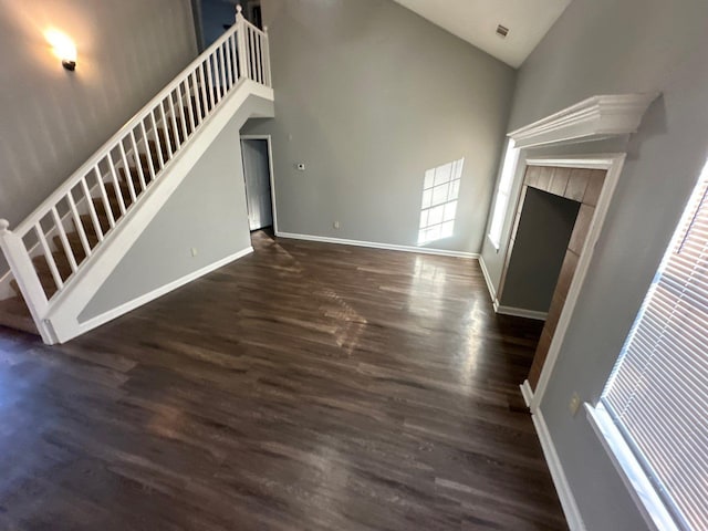 4136 Hampton Manor Ln, Memphis, TN 38128 - unfurnished living room featuring stairway, high vaulted ceiling, dark wood finished floors, a tile fireplace, and baseboards