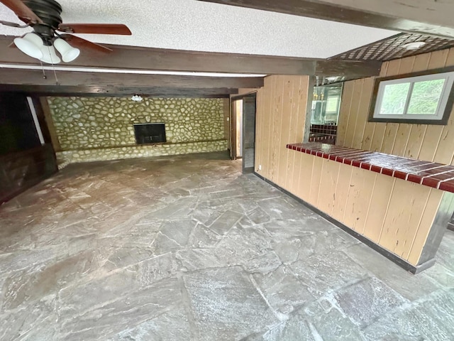 3751 Lakewood Dr N, Memphis, TN 38128 - bar with wooden walls, a fireplace, ceiling fan, and stone floors