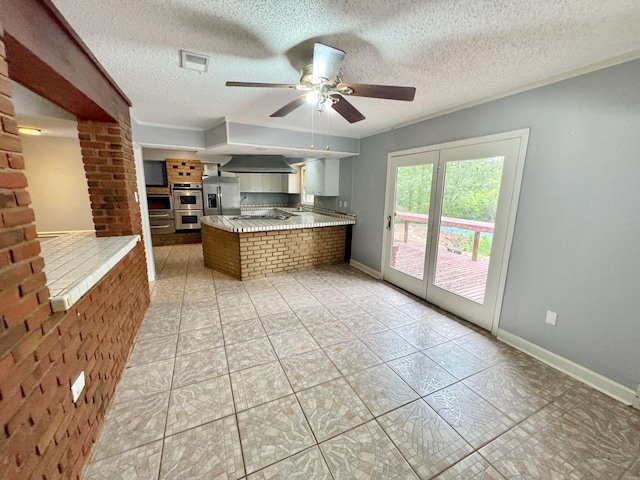 3751 Lakewood Dr N, Memphis, TN 38128 - kitchen featuring stainless steel appliances, a peninsula, ceiling fan, a textured ceiling, and baseboards