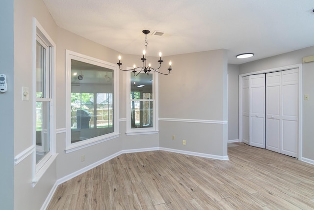 8432 Wood Shadows Ln, Memphis, TN 38018 - unfurnished dining area with light wood-type flooring, a chandelier, and baseboards