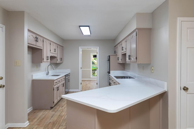 8432 Wood Shadows Ln, Memphis, TN 38018 - kitchen with a sink, a peninsula, dishwasher, light wood finished floors, and light countertops