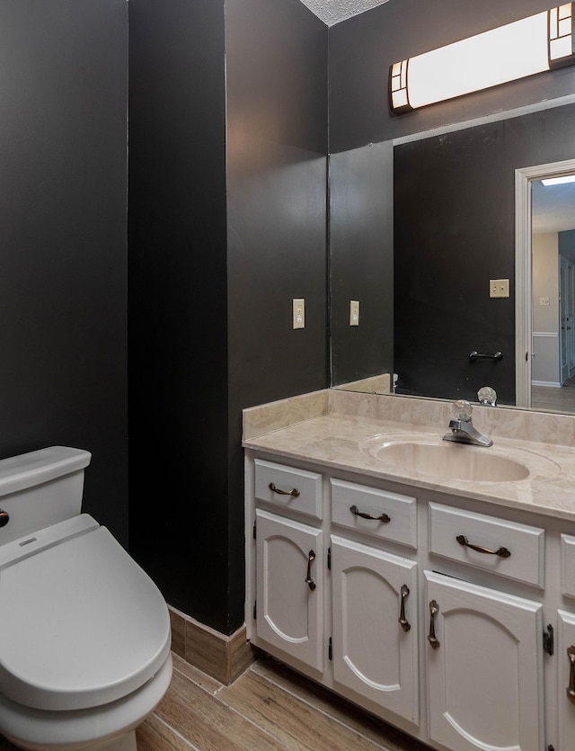 8432 Wood Shadows Ln, Memphis, TN 38018 - bathroom with wood finished floors, vanity, toilet, and baseboards