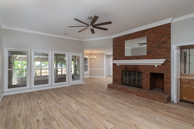 8432 Wood Shadows Ln, Memphis, TN 38018 - unfurnished living room featuring a ceiling fan, a chandelier, light wood-style floors, a fireplace, and crown molding