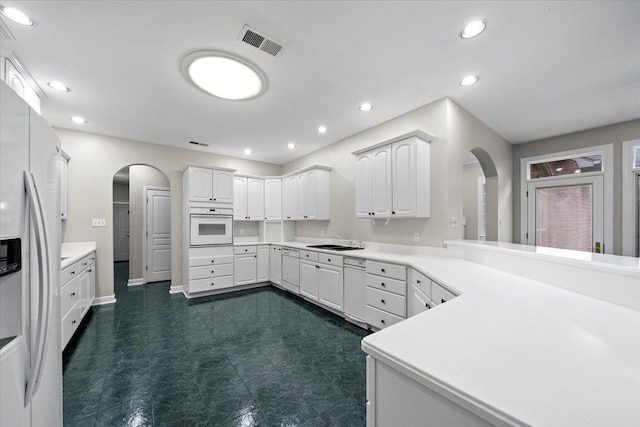 3559 Windgarden Cv, Memphis, TN 38125 - kitchen with arched walkways, oven, refrigerator with ice dispenser, recessed lighting, and white cabinetry