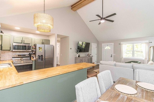 220 Harrison Rd, Michie, TN 38357 - kitchen featuring appliances with stainless steel finishes, butcher block counters, a peninsula, open floor plan, and high vaulted ceiling