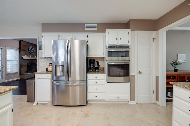 167 Ericson Rd, Memphis, TN 38018 - kitchen with stainless steel appliances, light stone counters, and white cabinetry