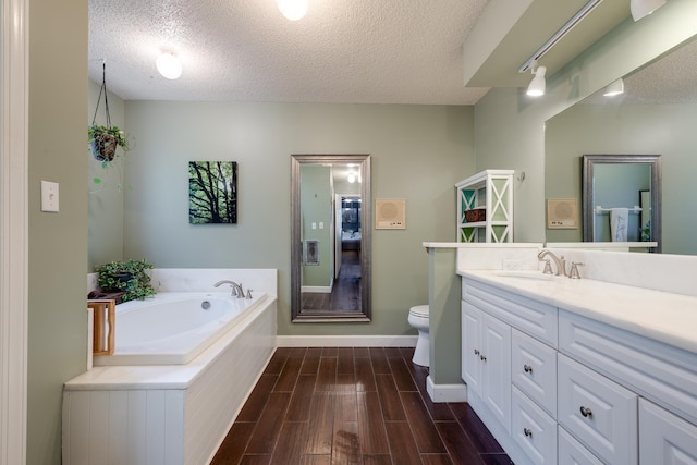 167 Ericson Rd, Memphis, TN 38018 - full bath featuring vanity, toilet, a textured ceiling, a garden tub, and wood finished floors