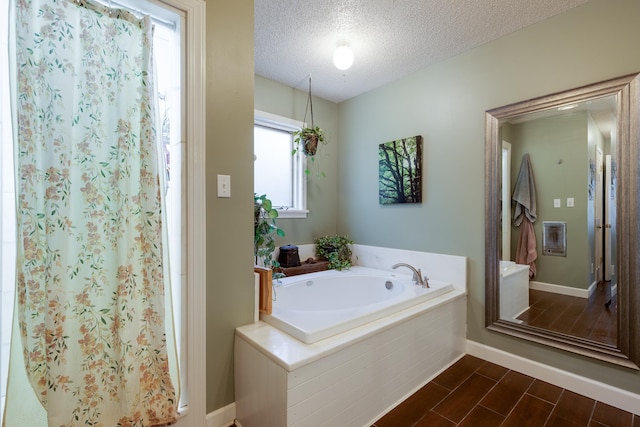 167 Ericson Rd, Memphis, TN 38018 - full bath with a textured ceiling, a garden tub, curtained shower, baseboards, and wood finished floors