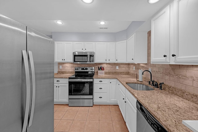 1822 Dragonfly Cv Unit 79, Germantown, TN 38138 - kitchen featuring appliances with stainless steel finishes, a sink, light tile patterned flooring, backsplash, and white cabinets
