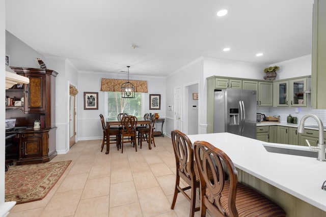1620 Saddle Chase Cv, Memphis, TN 38016 - kitchen featuring stainless steel fridge, green cabinets, a sink, a breakfast bar, and decorative backsplash