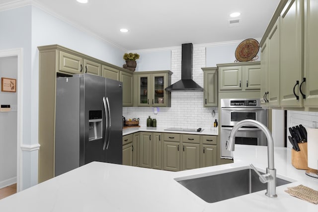 1620 Saddle Chase Cv, Memphis, TN 38016 - kitchen with appliances with stainless steel finishes, a sink, wall chimney range hood, decorative backsplash, and light countertops