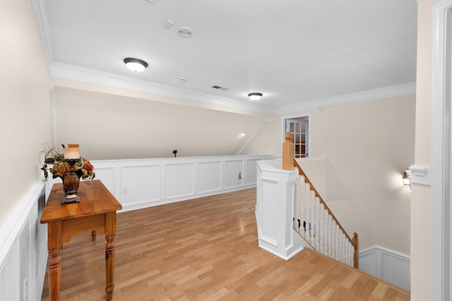 1620 Saddle Chase Cv, Memphis, TN 38016 - hallway with an upstairs landing, ornamental molding, a decorative wall, light wood-style flooring, and a wainscoted wall