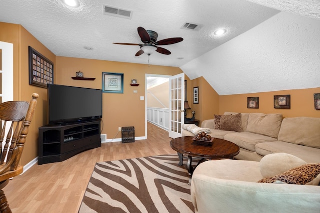 1620 Saddle Chase Cv, Memphis, TN 38016 - living room featuring a textured ceiling, light wood-style floors, ceiling fan, baseboards, and vaulted ceiling