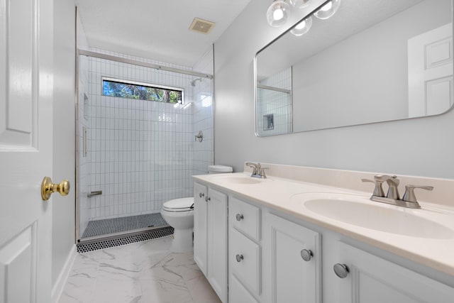 1620 Saddle Chase Cv, Memphis, TN 38016 - bathroom featuring marble look tile flooring, double vanity, toilet, and a tile shower