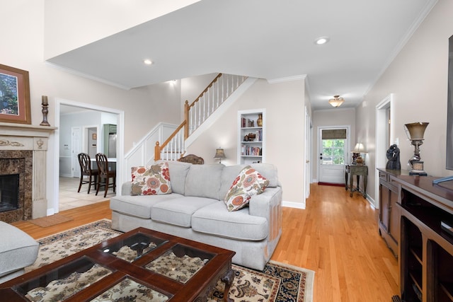 1620 Saddle Chase Cv, Memphis, TN 38016 - living area featuring crown molding, light wood-style flooring, baseboards, a fireplace, and stairs