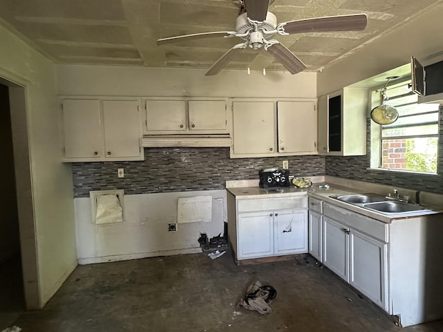 3421 Piney Woods Ave, Memphis, TN 38118 - kitchen featuring a sink, ceiling fan, white cabinets, backsplash, and concrete floors