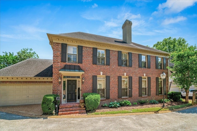 5239 Hedgewyck Ct, Memphis, TN 38117 - colonial inspired home with brick siding, a chimney, a garage, asphalt driveway, and a shingled roof