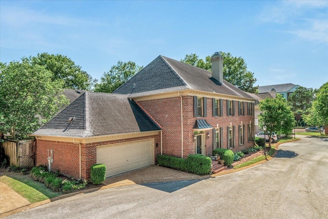 5239 Hedgewyck Ct, Memphis, TN 38117 - view of front of property with brick siding, a shingled roof, a chimney, and an attached garage