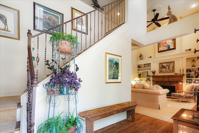5239 Hedgewyck Ct, Memphis, TN 38117 - stairway featuring ceiling fan, built in shelves, wood finished floors, a towering ceiling, and a fireplace