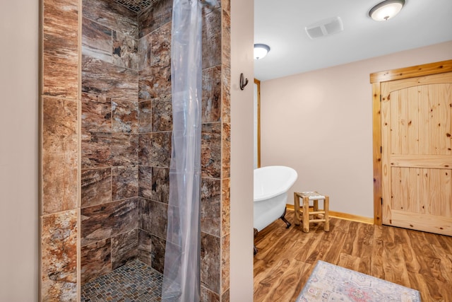 630 Raleigh-Lagrange Dr, Rossville, TN 38066 - bathroom featuring wood finished floors, a freestanding bath, a shower stall, and baseboards