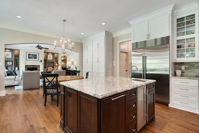 7726 Chapel Creek Pkwy N, Memphis, TN 38016 - kitchen featuring ceiling fan, built in fridge, white cabinetry, a fireplace, and crown molding