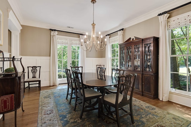 7726 Chapel Creek Pkwy N, Memphis, TN 38016 - dining space with a chandelier, a decorative wall, crown molding, a wainscoted wall, and dark wood-type flooring