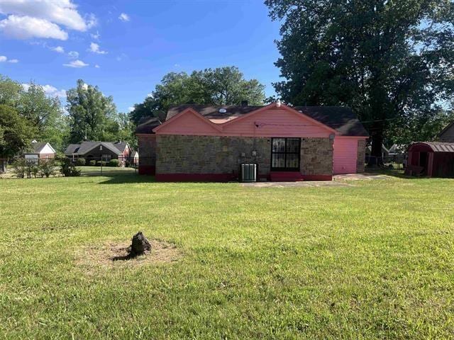 760 E Mckellar Ave, Memphis, TN 38106 - back of house featuring a yard, stone siding, and cooling unit