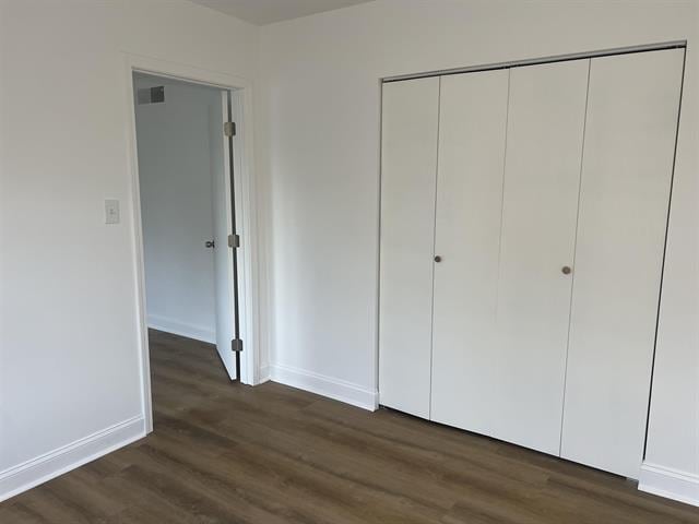 760 E Mckellar Ave, Memphis, TN 38106 - unfurnished bedroom featuring dark wood-style flooring, baseboards, and a closet