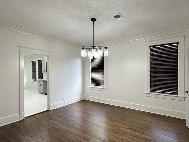 1151 Tanglewood St, Memphis, TN 38114 - empty room with crown molding, a chandelier, dark wood-style flooring, baseboards, and a textured ceiling
