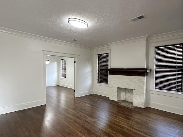 1151 Tanglewood St, Memphis, TN 38114 - unfurnished living room with a textured ceiling, wood finished floors, crown molding, baseboards, and a brick fireplace