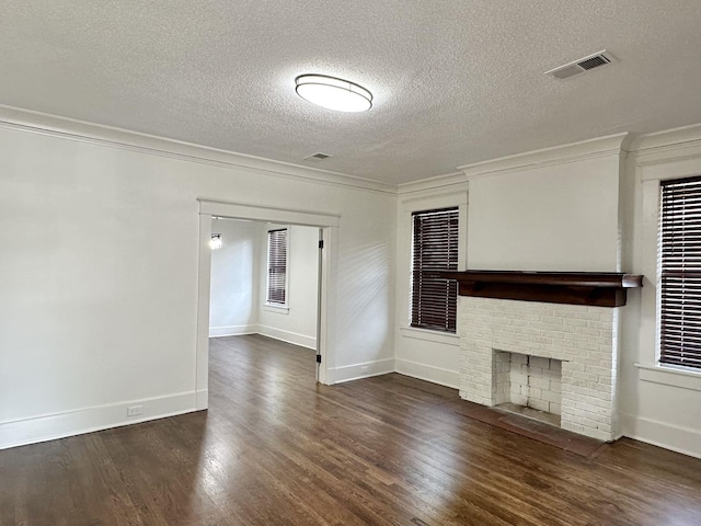 1151 Tanglewood St, Memphis, TN 38114 - unfurnished living room featuring wood finished floors, crown molding, a textured ceiling, baseboards, and a brick fireplace