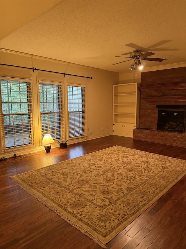917 Valleyview Ln, Collierville, TN 38017 - unfurnished living room featuring a ceiling fan, dark wood finished floors, a textured ceiling, and a brick fireplace