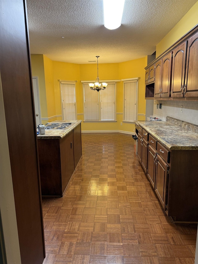 917 Valleyview Ln, Collierville, TN 38017 - kitchen with dark brown cabinetry, a chandelier, a textured ceiling, decorative light fixtures, and baseboards