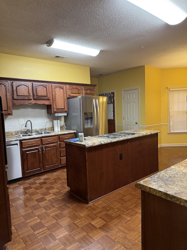917 Valleyview Ln, Collierville, TN 38017 - kitchen with a sink, stainless steel appliances, a textured ceiling, a kitchen island, and dark brown cabinetry