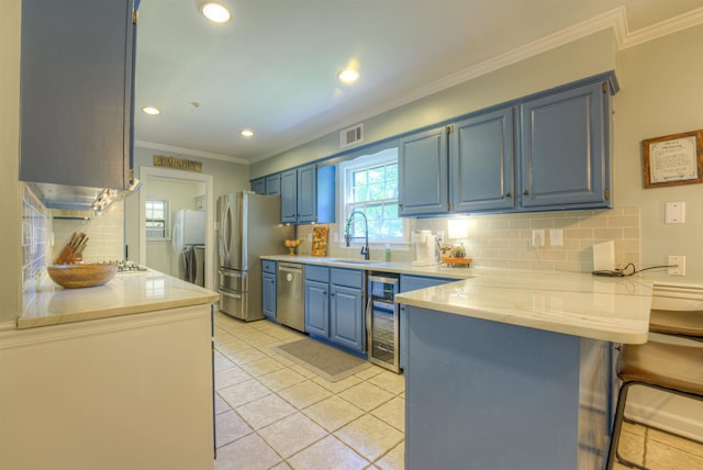7352 Magnolia Ridge Dr, Germantown, TN 38138 - kitchen with blue cabinets, a sink, appliances with stainless steel finishes, wine cooler, and ornamental molding