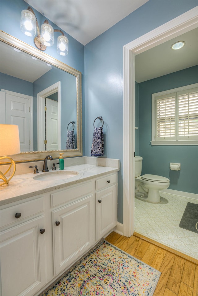 7352 Magnolia Ridge Dr, Germantown, TN 38138 - bathroom with wood finished floors, toilet, vanity, and baseboards