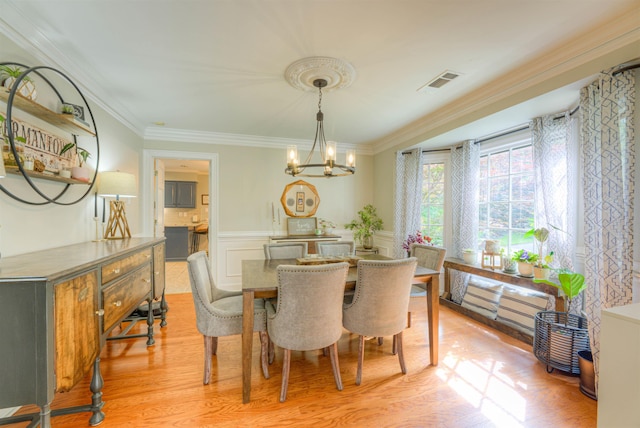 7352 Magnolia Ridge Dr, Germantown, TN 38138 - dining space with a chandelier, ornamental molding, light wood finished floors, and a wainscoted wall