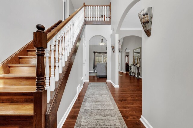 5578 Southern Winds Dr, Arlington, TN 38002 - foyer entrance with arched walkways, a towering ceiling, stairway, wood finished floors, and baseboards