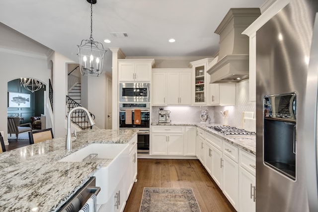125 Magnolia Park Dr, Rossville, TN 38066 - kitchen with stainless steel appliances, a chandelier, custom exhaust hood, glass insert cabinets, and crown molding